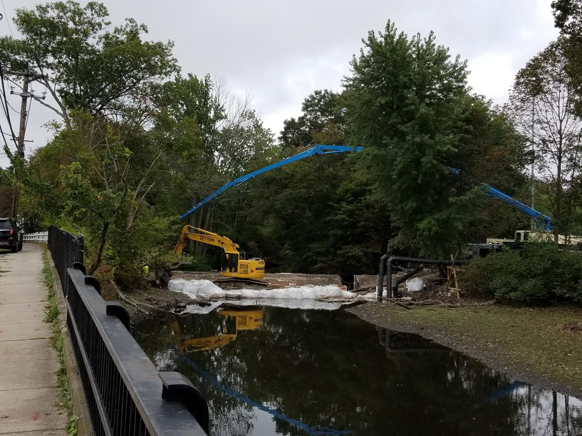 Pump truck fully extended to reach the opposite side of the dam.