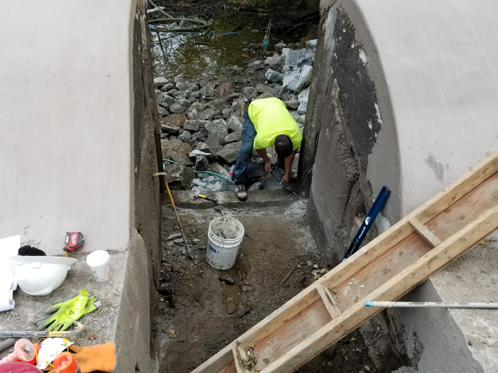 Chiseling out concrete for the installation of the stop log assembly